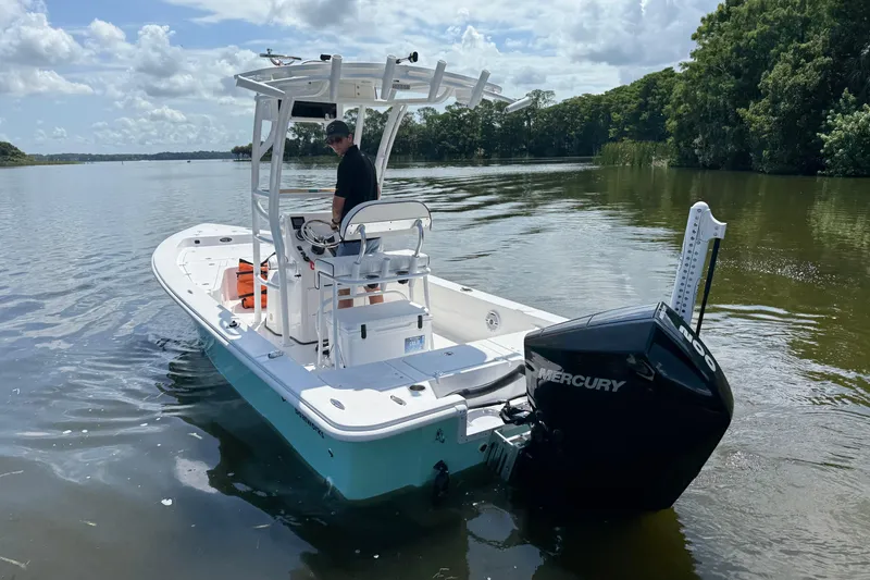 Slide: The Image of 2024 Piranha Boatworks Casador B2250 on calm water, featuring a Mercury engine. - 21