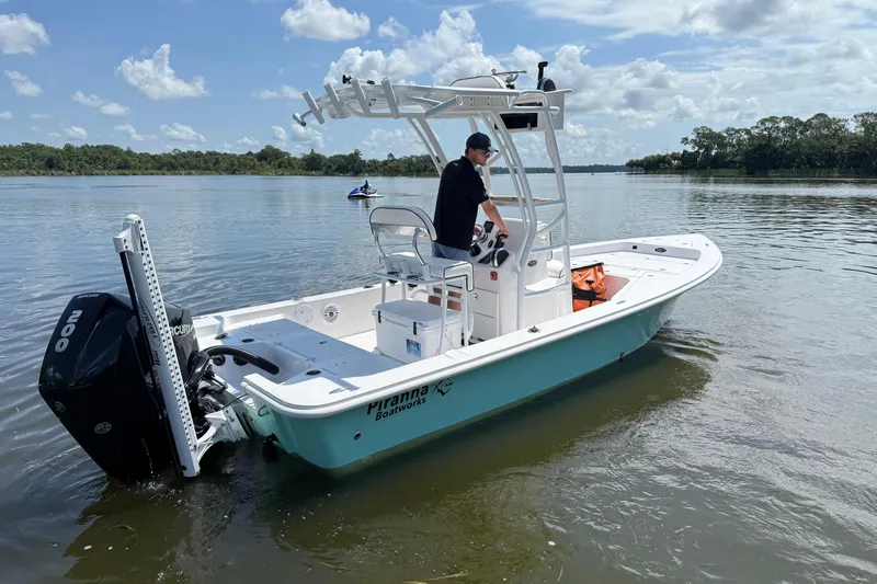 Slide: The Image of 2024 Piranha Boatworks Casador B2250 on calm water, featuring a sleek design and powerful engine. - 25