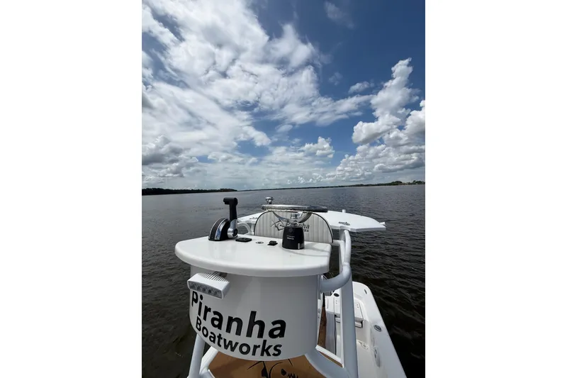 Slide: The Image of 2024 Piranha Boatworks Casador B2250 on calm water under a cloudy sky. - 35