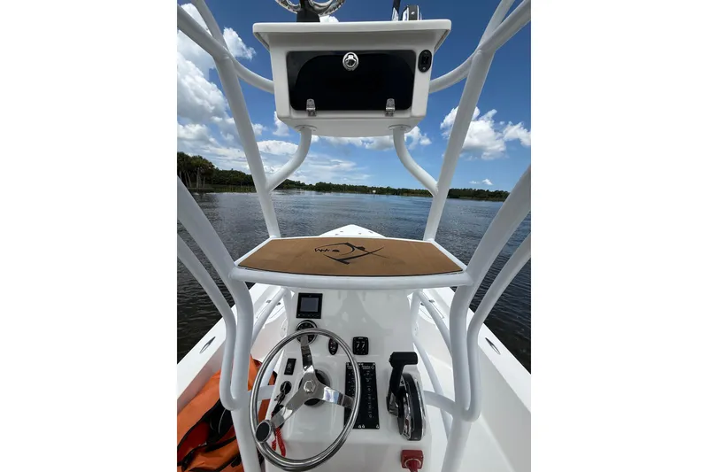 Slide: The Image of 2024 Piranha Boatworks Casador B2250 helm view on a sunny day, showcasing steering and controls. - 36