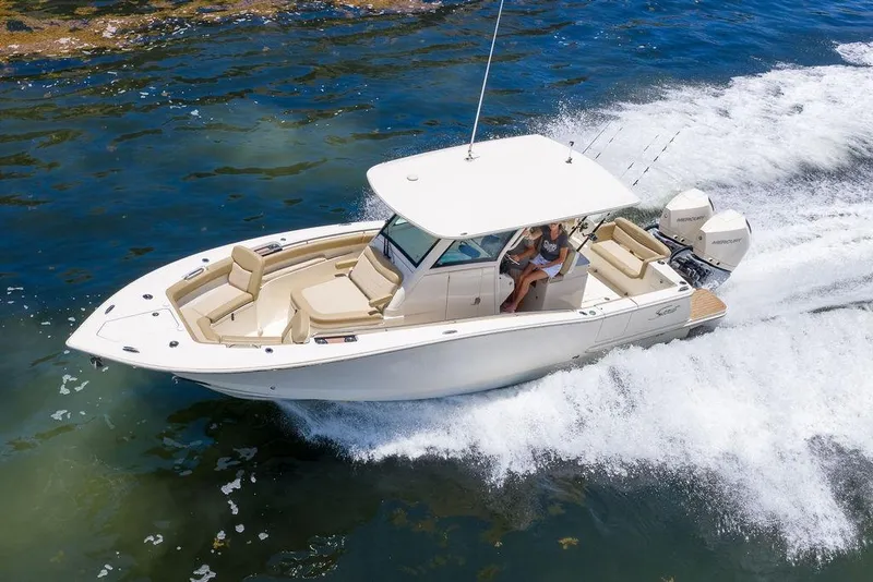Slide: The Image of 2021 Scout 305 LXF boat cruising on water with passengers, showcasing luxury and performance. - 15