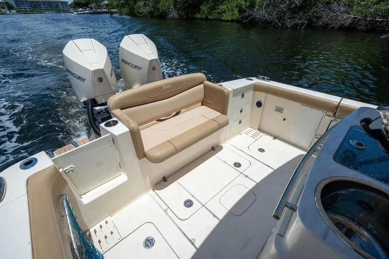 Slide: The Image of 2021 Scout 305 LXF boat interior with dual Mercury engines on a sunny day. - 22