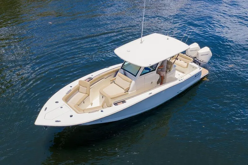 Slide: The Image of 2021 Scout 305 LXF boat on calm water, featuring sleek design and twin engines. - 2