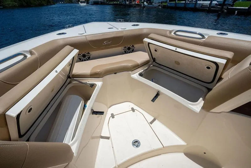 Slide: The Image of 2021 Scout 305 LXF boat interior with open storage compartments and tan seating. - 21
