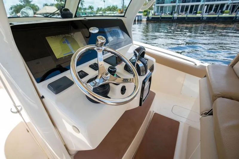 Slide: The Image of 2021 Scout 305 LXF boat helm with steering wheel and navigation display. - 29