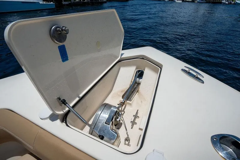 Slide: The Image of Anchor compartment of 2021 Scout 305 LXF boat, open on calm water. - 19