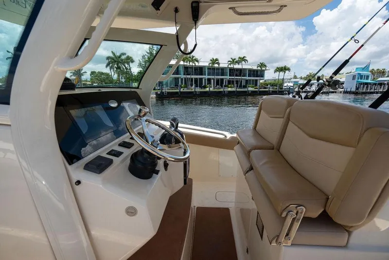 Slide: The Image of Interior view of 2021 Scout 305 LXF boat with steering wheel and seating. - 33