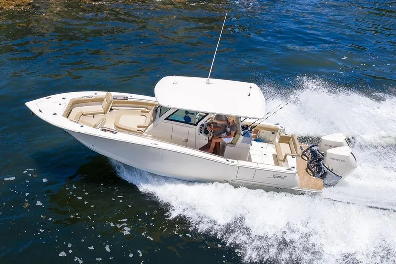 Slide: The Image of 2021 Scout 305 LXF boat cruising on water with passengers onboard. - 3