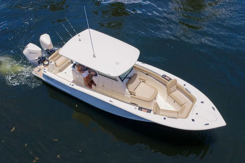 Slide: The Image of 2021 Scout 305 LXF boat cruising on water, featuring sleek design and dual outboard engines. - 5