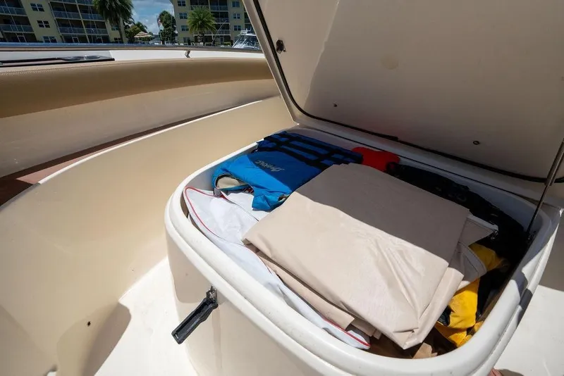 Slide: The Image of Storage compartment of 2021 Scout 305 LXF boat filled with gear and life jackets. - 20