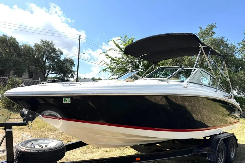 Slide: The Image of 2007 Cobalt 212 boat on trailer, black hull, red stripe, sunny day. - 2