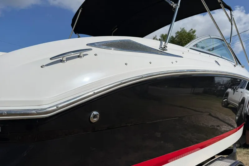 Slide: The Image of 2007 Cobalt 212 boat with sleek black and white design under a clear blue sky. - 14