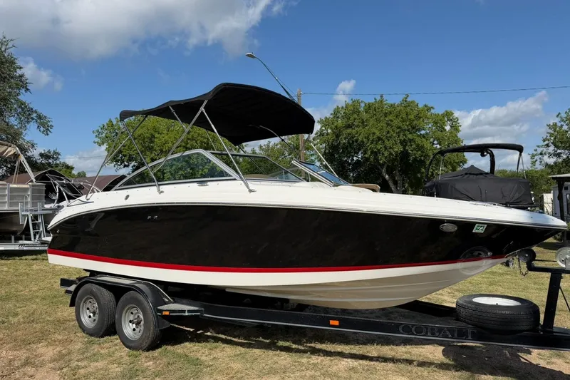 Slide: The Image of 2007 Cobalt 212 boat on trailer, black hull, red stripe, parked outdoors. - 7