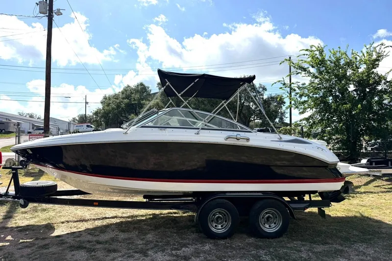 Slide: The Image of 2007 Cobalt 212 boat on trailer, black and white design, parked outdoors. - 15