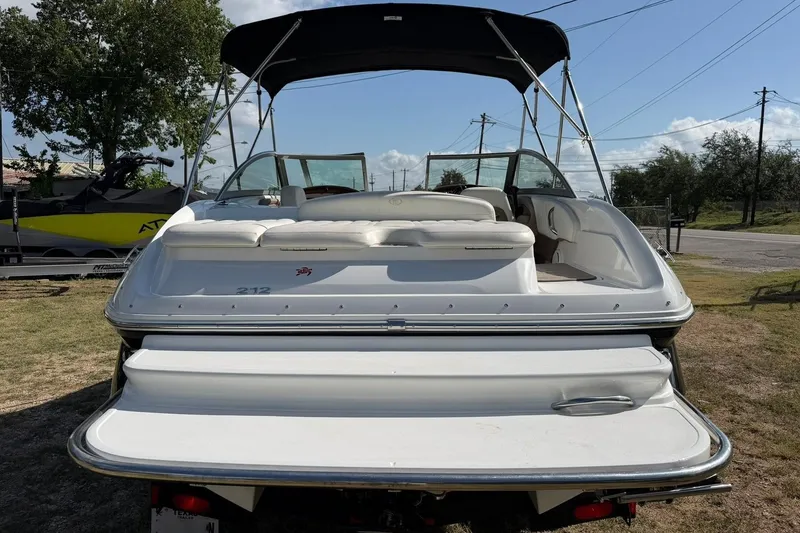 Slide: The Image of 2007 Cobalt 212 boat with white seating and canopy, parked on grass. - 21