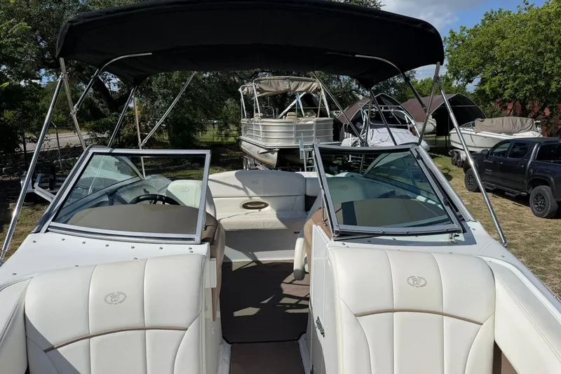 Slide: The Image of 2007 Cobalt 212 boat with white interior and black canopy, parked outdoors. - 47