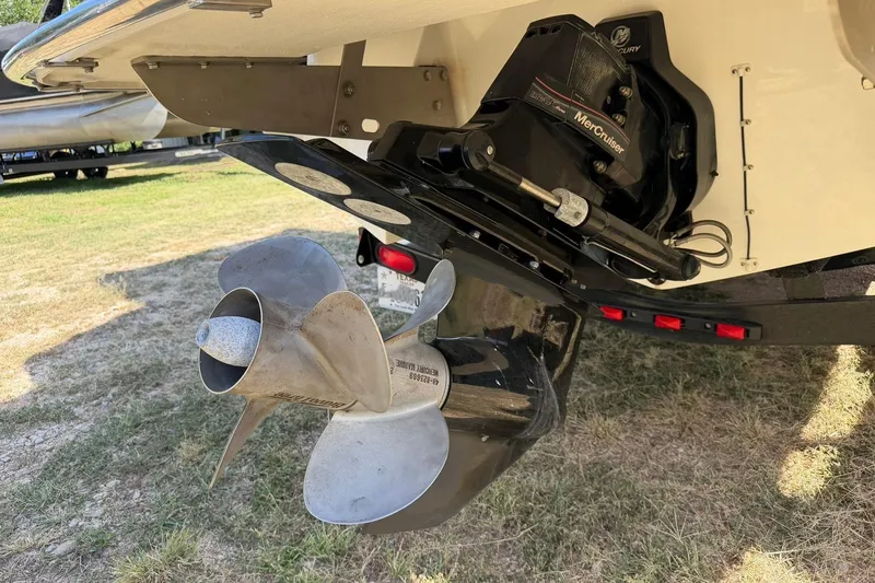 Slide: The Image of 2007 Cobalt 212 boat with MerCruiser outdrive and propeller on grassy surface. - 22