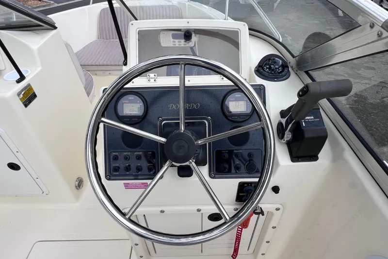 Slide: The Image of Steering console of a 2001 Scout 202 Dorado boat with gauges and controls. - 28