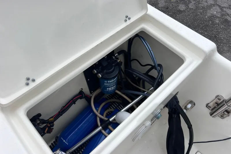 Slide: The Image of Open compartment of a 2001 Scout 202 Dorado boat showing engine components and wiring. - 18