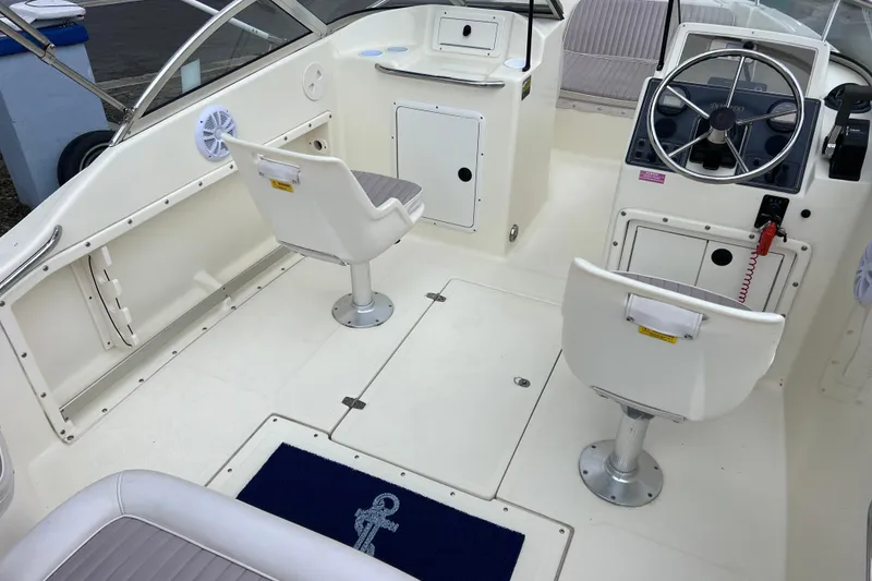 Slide: The Image of 2001 Scout 202 Dorado boat interior with steering wheel, seating, and storage compartments. - 14