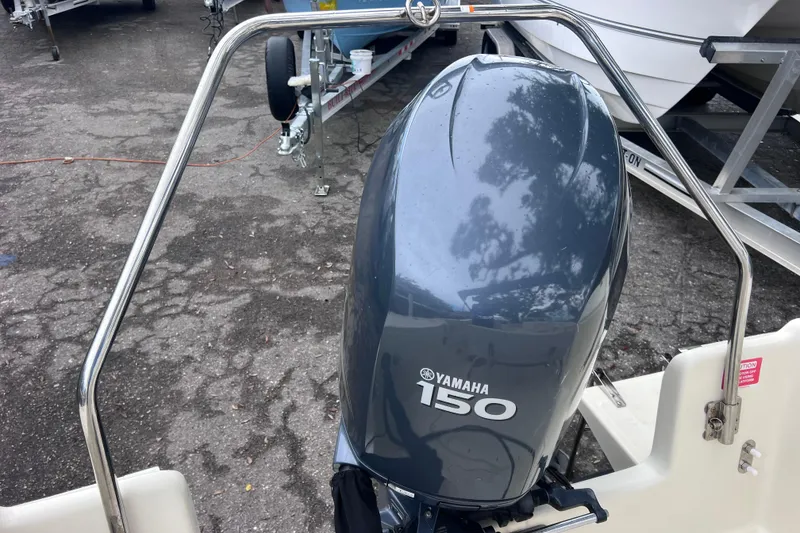 Slide: The Image of Yamaha 150 outboard motor on a 2001 Scout 202 Dorado boat, parked on pavement. - 17