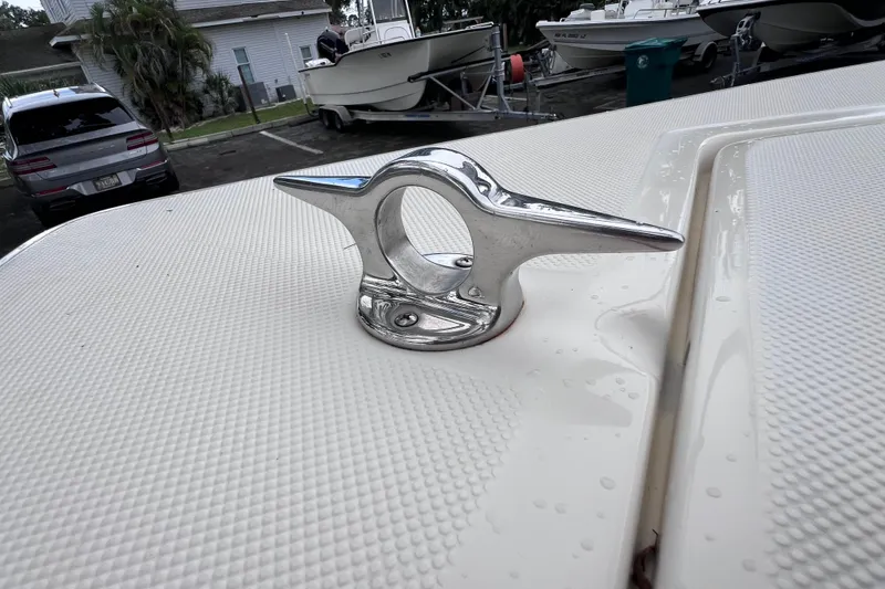 Slide: The Image of Chrome cleat on 2001 Scout 202 Dorado boat deck, surrounded by parked vehicles. - 37