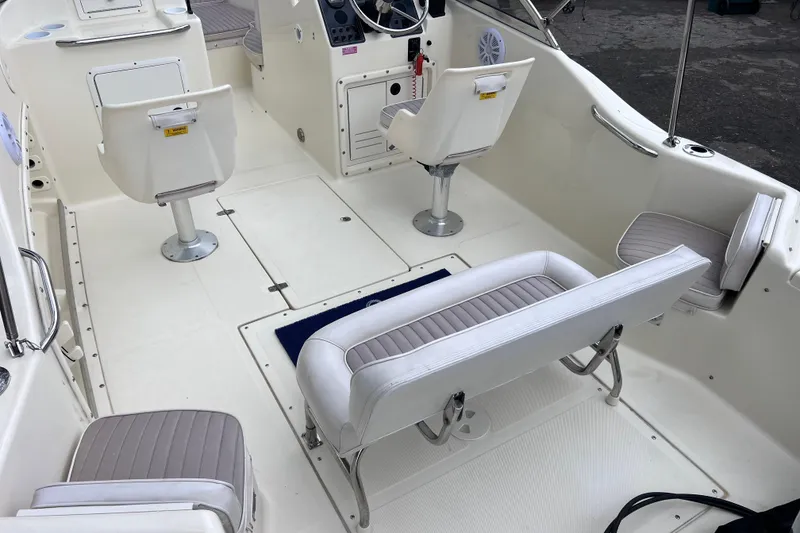 Slide: The Image of Interior of a 2001 Scout 202 Dorado boat with white seating and steering console. - 13