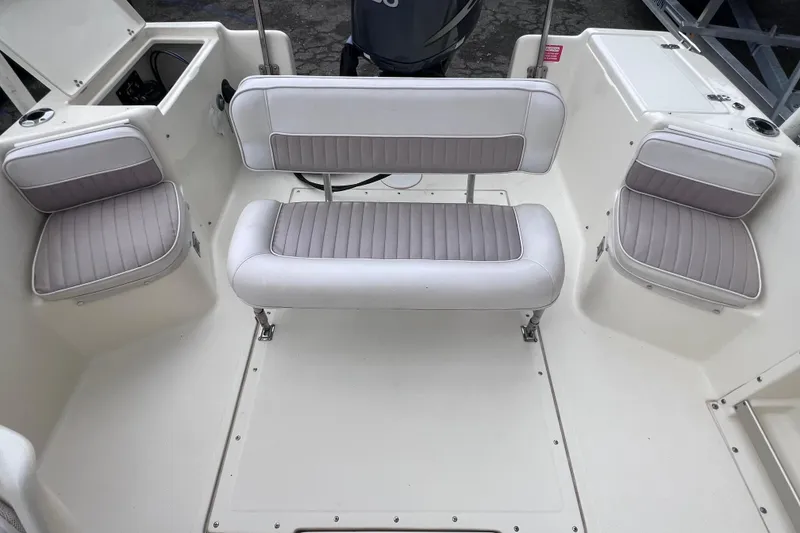 Slide: The Image of Interior seating of a 2001 Scout 202 Dorado boat, featuring cushioned benches. - 16