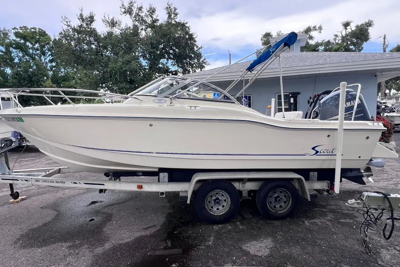 Slide: The Image of 2001 Scout 202 Dorado boat on trailer, parked outdoors near a building. - 5