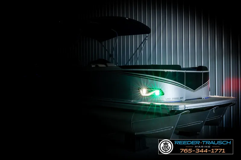 Slide: The Image of 2026 Avalon LSZ ENT pontoon boat with illuminated lights in a dimly lit setting. - 4
