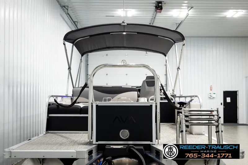 Slide: The Image of 2026 Avalon LSZ ENT pontoon boat in a showroom with canopy and seating. - 7