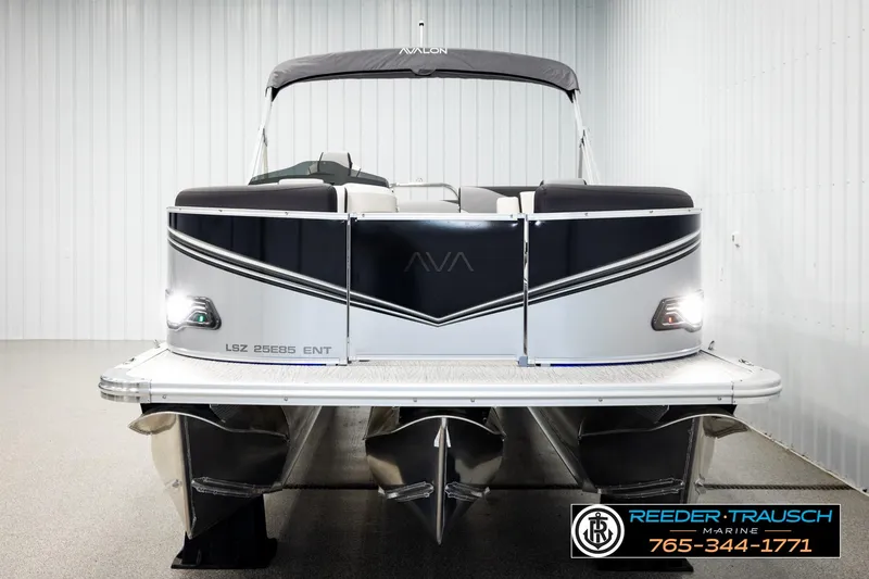 Slide: The Image of 2026 Avalon LSZ ENT pontoon boat in showroom, front view with sleek design. - 8