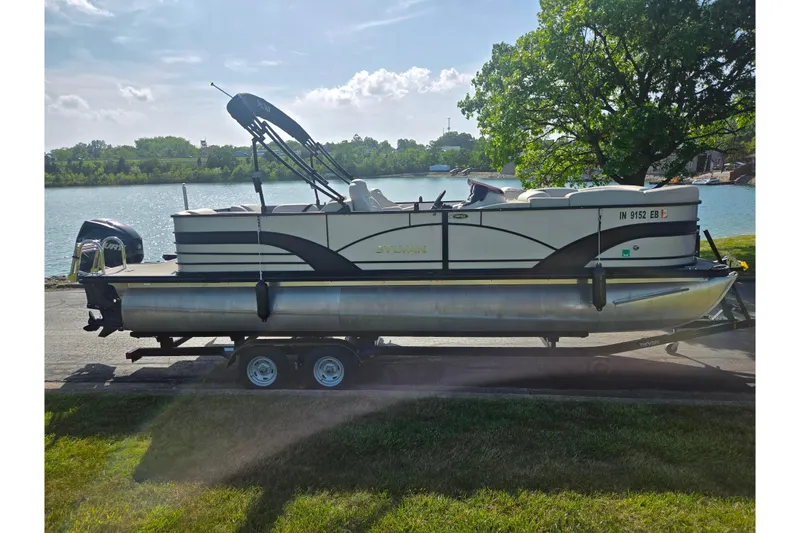 The Image of 2018 Sylvan Mirage Cruise 8522 LZ LE pontoon boat on trailer by a lake. - 10