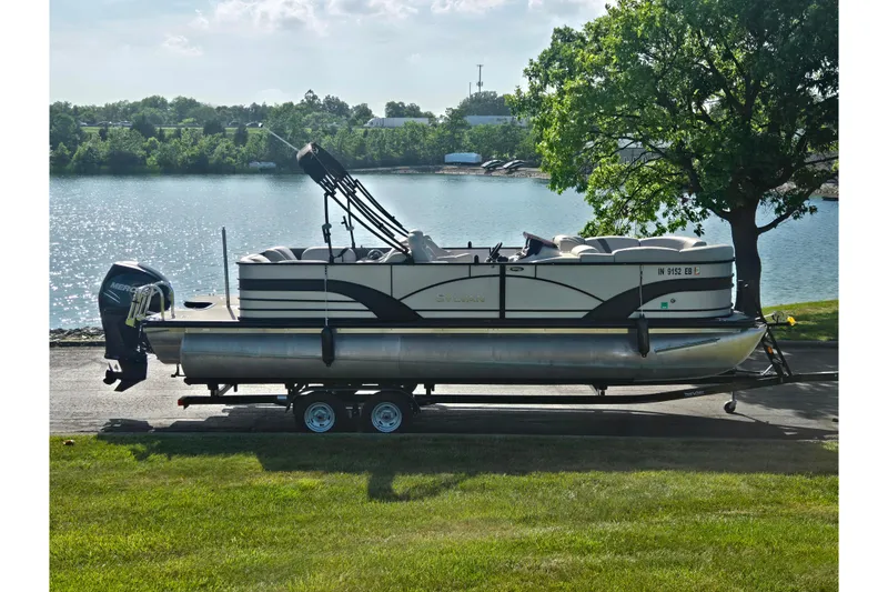 Slide: The Image of 2018 Sylvan Mirage Cruise 8522 LZ LE pontoon boat on trailer by a lake. - 0