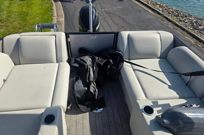 Slide: The Image of 2018 Sylvan Mirage Cruise 8522 LZ LE boat interior with cushioned seating and cup holders. - 17