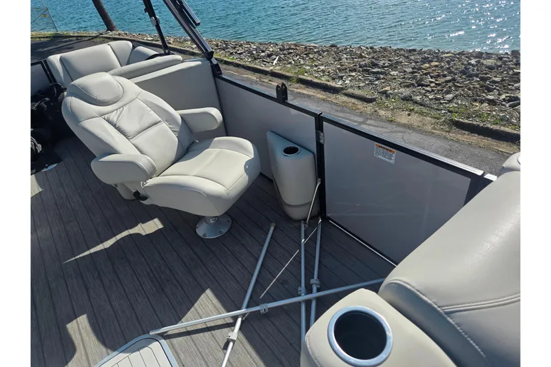 Slide: The Image of 2018 Sylvan Mirage Cruise 8522 LZ LE boat interior with plush seating by the water. - 13