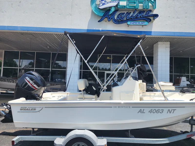 Slide: The Image of A 2023 Boston Whaler 150 Montauk on a trailer in front of a building with a "Marine Group" sign. - 5