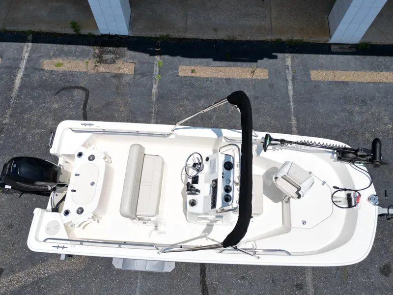 Slide: The Image of Aerial view of a 2023 Boston Whaler 150 Montauk. White deck, helm, and seating bench visible. - 3