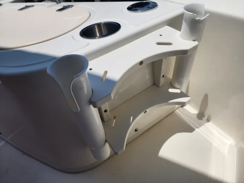 Slide: The Image of The image shows part of the interior of a 2023 Boston Whaler 150 Montauk with cup holders and storage. - 9
