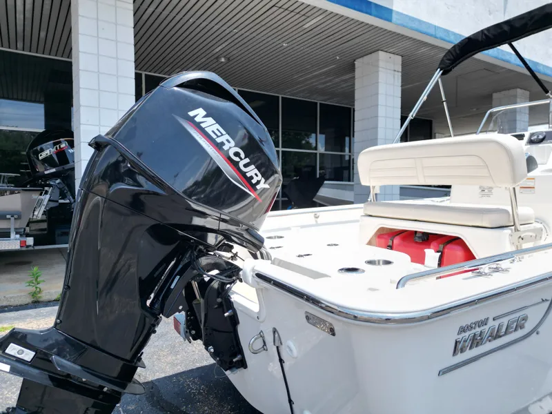 Slide: The Image of A 2023 Boston Whaler 150 Montauk with a Mercury outboard motor, parked in front of a building. - 18