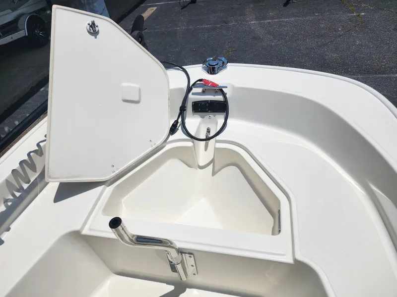 Slide: The Image of The image shows the bow area of a 2023 Boston Whaler 150 Montauk with an open storage compartment. - 19