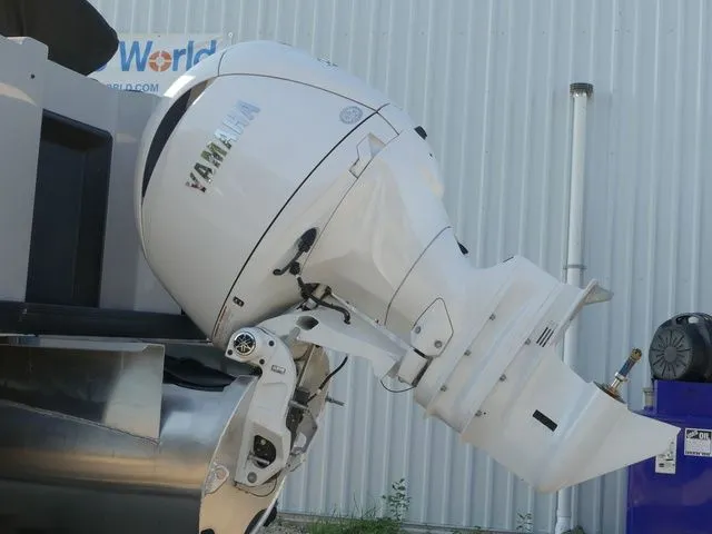 Slide: The Image of A white outboard motor is mounted on a boat, positioned in front of a corrugated metal building. - 7