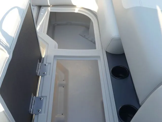 Slide: The Image of The image shows an open storage compartment in a boat with white upholstery and cup holders. - 40