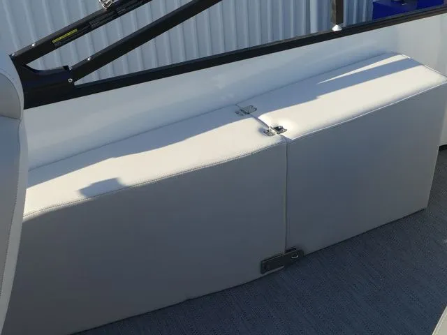 Slide: The Image of A white seating area on a boat with a black railing and gray flooring. - 24