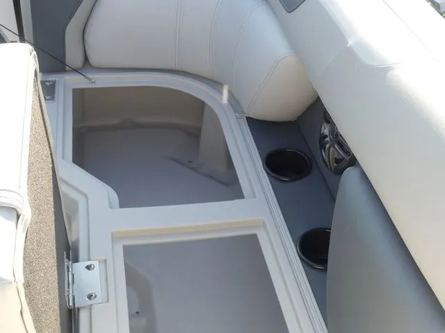 Slide: The Image of The image shows the interior of a Sweetwater SW 2086 FS boat with storage space and cup holders. - 38