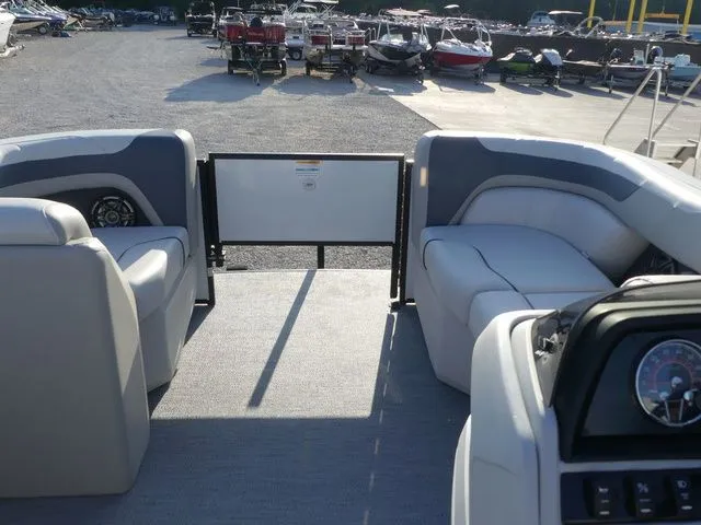 Slide: The Image of The image shows the interior of a Sweetwater SW 2086 FS pontoon boat with gray seating and a helm. - 32