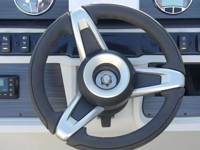 Slide: The Image of The image shows a modern boat helm with a sleek, silver steering wheel and instrument display. - 43