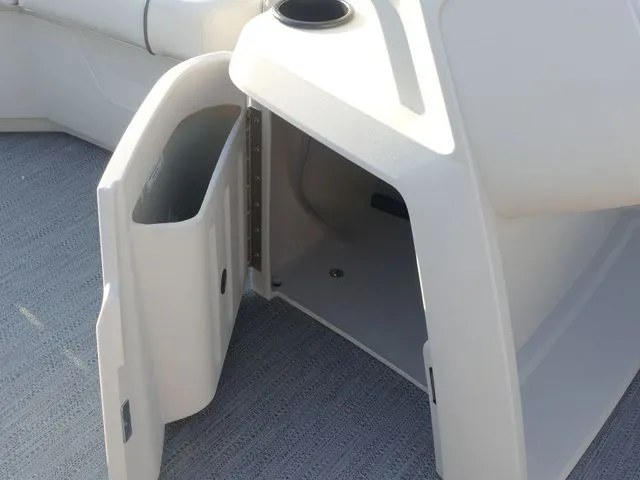 Slide: The Image of An open storage compartment on a Sweetwater SW 2086 FS boat, featuring gray carpet flooring. - 50