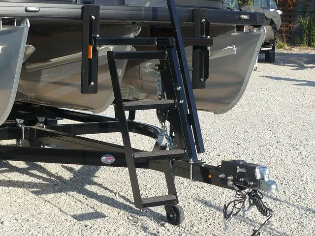 Slide: The Image of A Sweetwater SW 2086 FS boat trailer with a black frame and silver pontoons on gravel. - 14