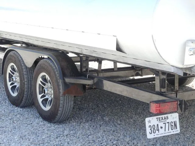 Slide: The Image of A dual-axle trailer with a Texas license plate is parked on gravel. - 11